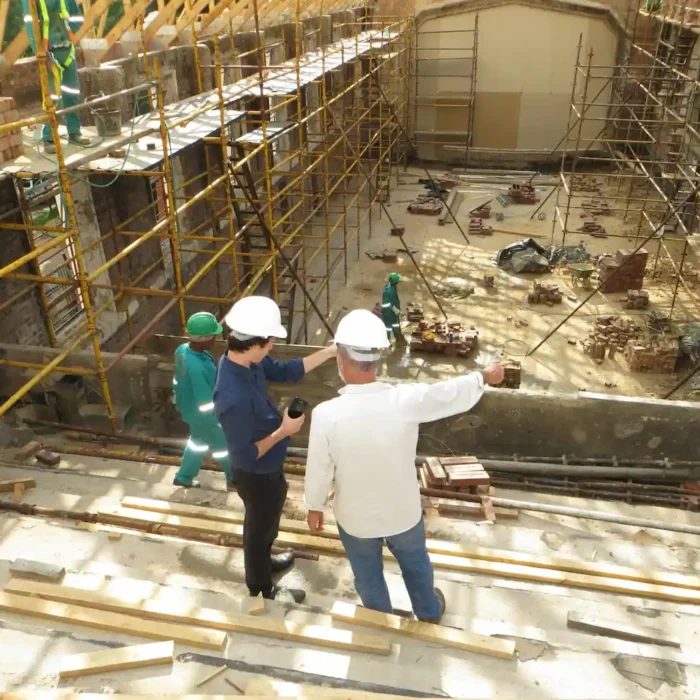 Contractors inspecting a large-scale scaffolding setup at a construction project